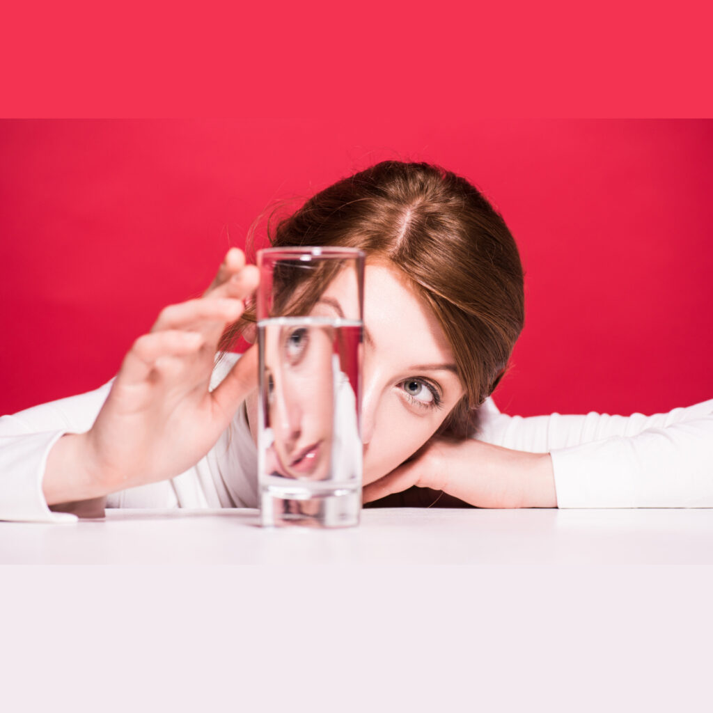 אישה בורוד נוגעת בכוס מים