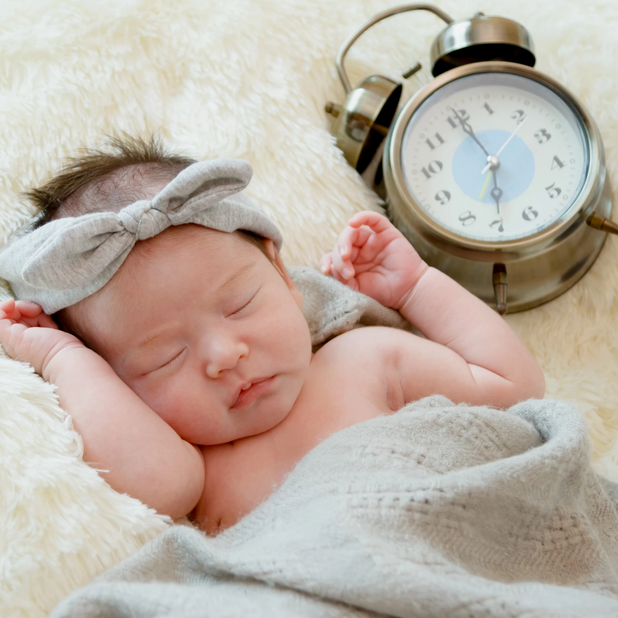 תינוק ישן עם שעון לידו. האם השעון משפיע על השינה?